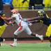 Michigan running back Thomas Rawls attempts to run the ball around Illinois linebacker Jonathan Brown as teammate offensive linesman Patrick Omameh moves in during the first second at Michigan Stadium on Saturday.  Melanie Maxwell I AnnArbor.com